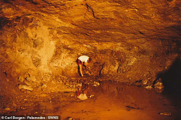 Pictured: A barefoot man digs inside the Lemminkäinen Temple in Finland