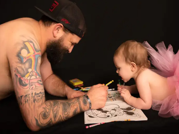 Dad and little daughter together wearing princess dresses for a photo